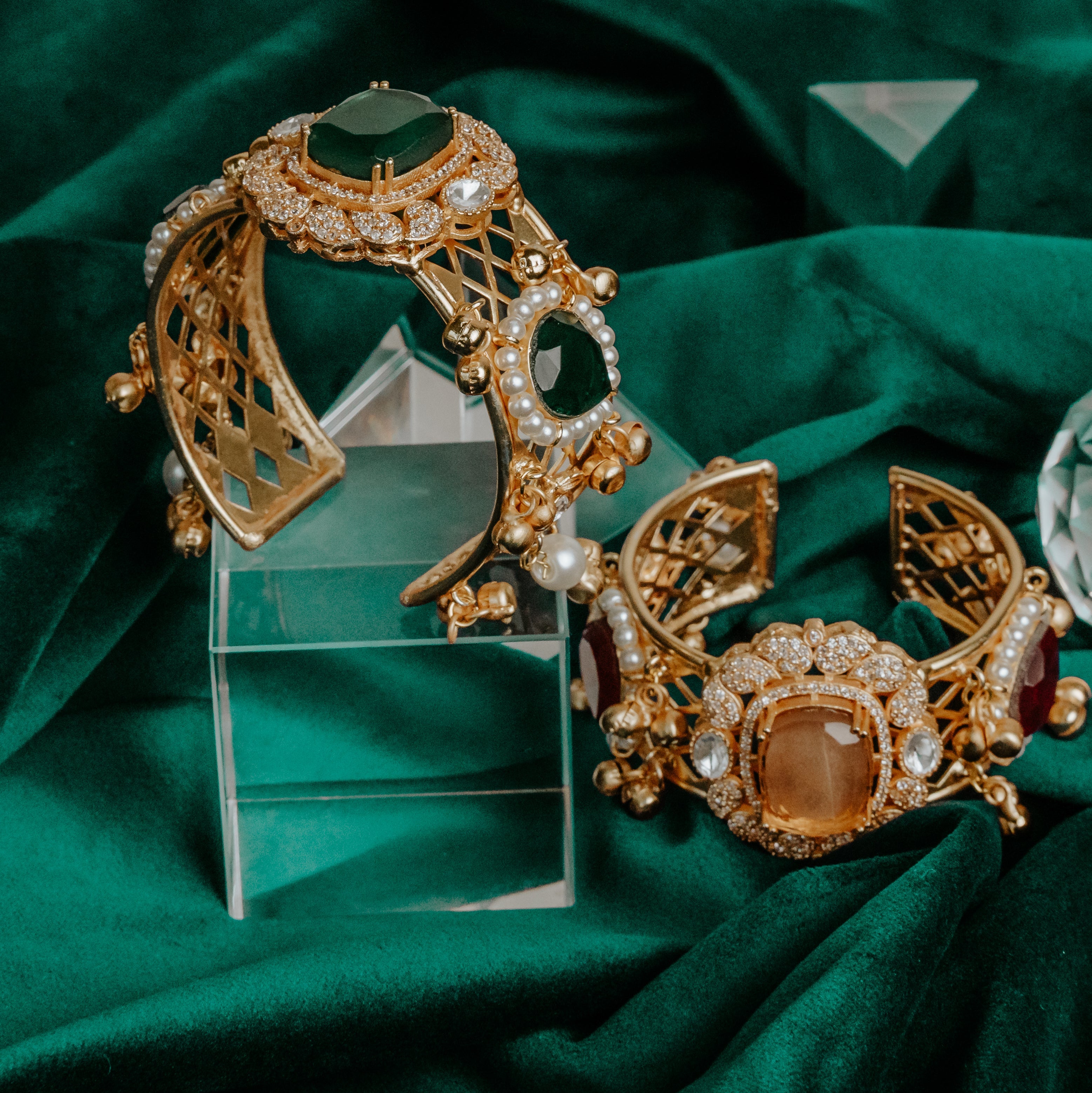 Gold and gemstone jewelry on a green fabric background