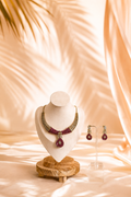 Jewelry set including a necklace and earrings on a mannequin bust with a soft, blurred background.