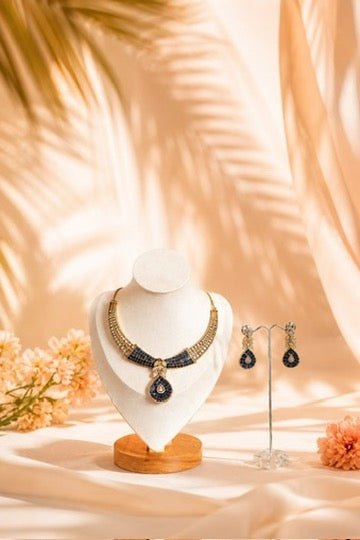 Necklace and earrings on display with a soft, warm background